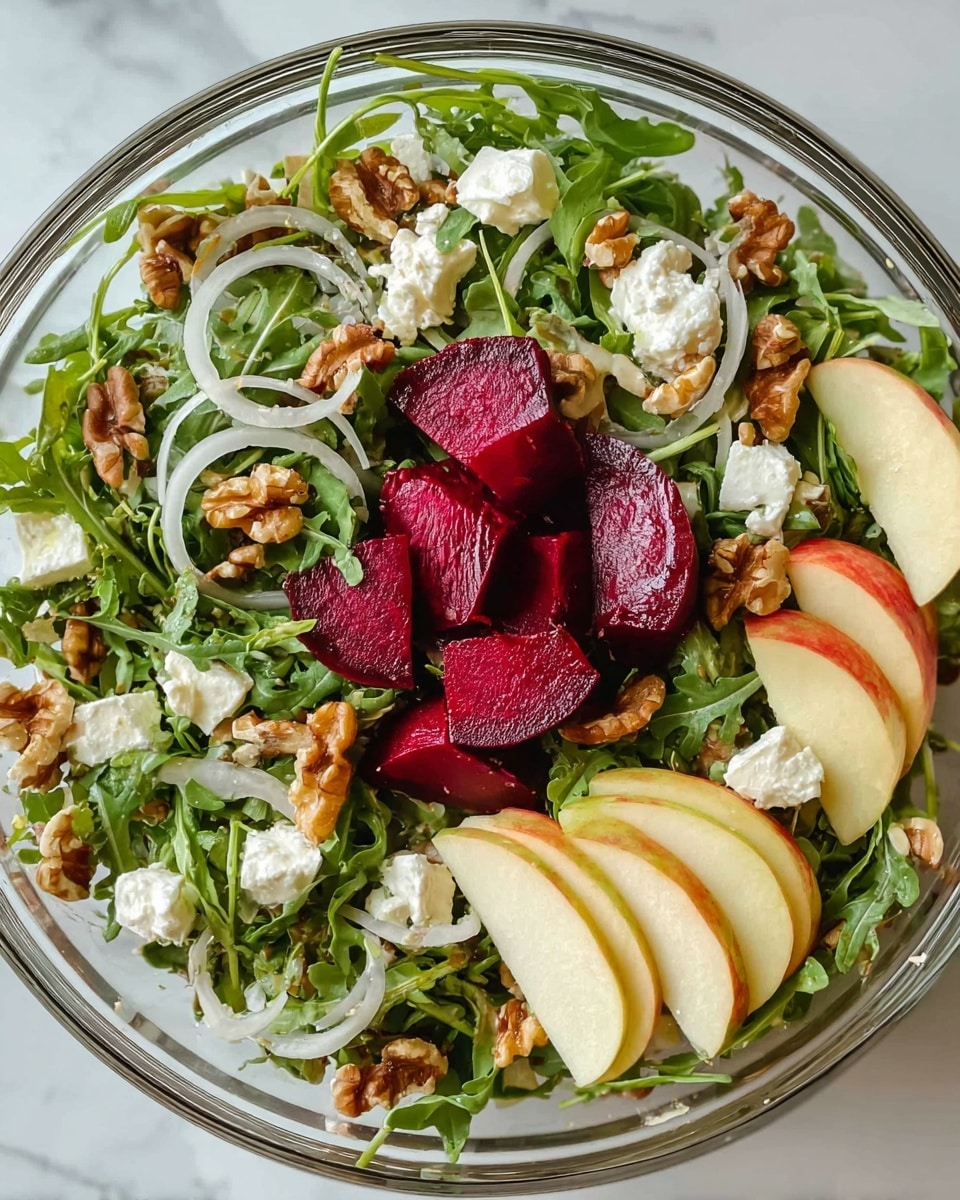 This image shows a clear glass bowl filled with a fresh salad. The bottom and middle layers are made up of dark green arugula leaves with a rough texture. Scattered throughout are thin white onion slices and small, rough-textured pieces of white goat cheese. Bright red beet chunks with a smooth, moist surface are placed on top. Around the edges, thin yellowish slices of apple with a smooth texture are positioned. Small pieces of light brown walnuts are mixed in, adding a rough texture. The bowl is placed on a white marbled surface. photo taken with an iphone --ar 4:5 --v 7