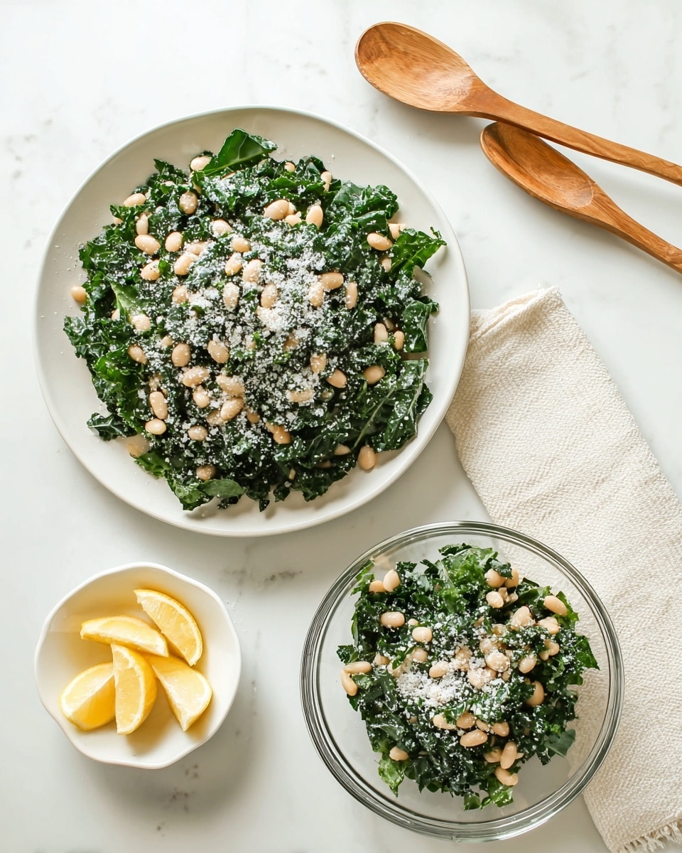 The image shows two bowls of salad on a white marbled surface, one large white bowl and one smaller clear glass bowl. Both bowls contain a mix of dark green kale leaves and light beige white beans, topped with a layer of finely grated white cheese that is scattered over the salad, giving a snowy texture. To the right, on a white marbled surface, there is a white bowl containing yellow lemon wedges, placed beside a cream-colored textured cloth. The overall look is fresh and healthy with contrasting colors of dark green, beige, white, and yellow. photo taken with an iphone --ar 4:5 --v 7
