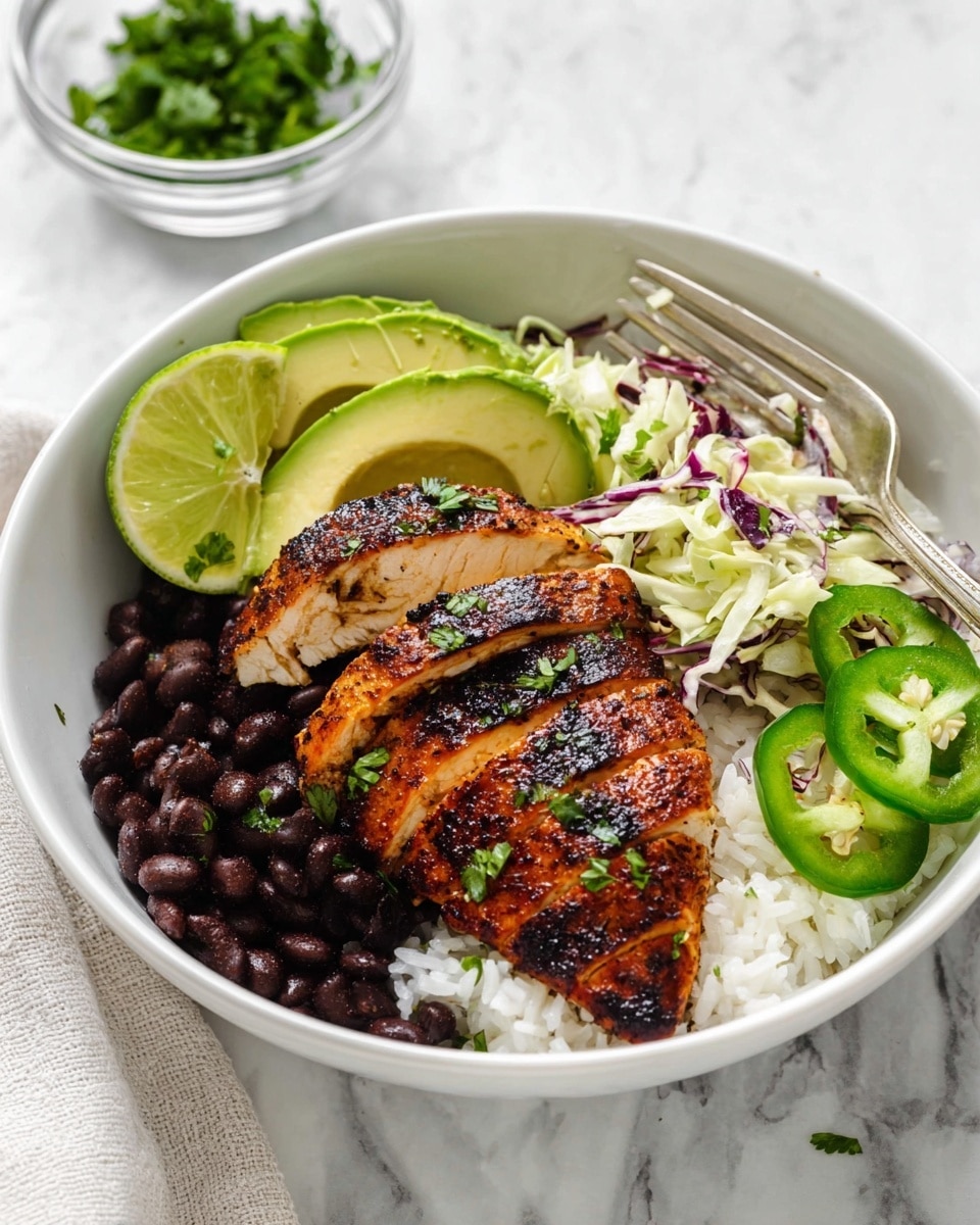 A white bowl contains a layered dish starting with a base of white rice mixed with black beans, placed on the left side. On top of the rice and beans sits a bright green lime wedge. To the right, there are three slices of grilled chicken breast with distinct dark grill marks, golden brown skin, and a slightly charred texture sprinkled with chopped green herbs. Above the chicken are three avocado slices arranged in a fan shape with a smooth, light green flesh. Two slices of fresh jalapeño pepper with bright green color and visible seeds rest on the avocado and near the chicken. Behind the avocado is a mix of shredded cabbage with pale green and purple strands, also topped with small green herb pieces. A silver fork rests on the rice and beans edge of the bowl. In the background, there is a small clear glass bowl filled with chopped green herbs on a white marbled texture surface. photo taken with an iphone --ar 4:5 --v 7