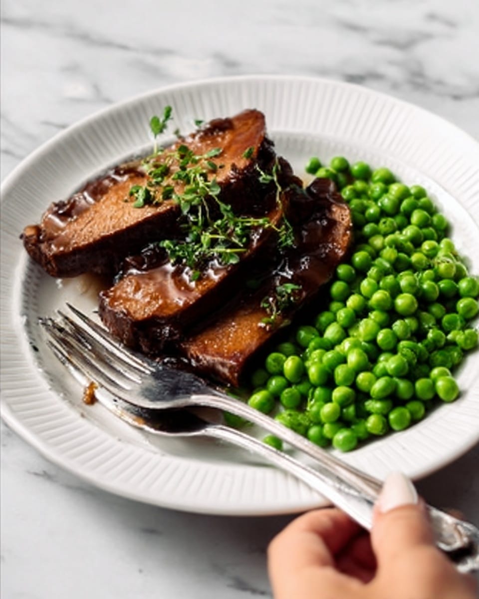 The dish shows a white plate with three thick slices of dark brown cooked meat stacked on each other on the left side. To the right, there is a small pile of bright green peas. The meat has some sauce on top and is sprinkled with small green herb pieces. A silver fork is placed diagonally on the plate, with the tines resting on the meat and the handle moving off the lower edge of the plate, held by a woman's hand. The background is a white marbled surface. Photo taken with an iphone --ar 4:5 --v 7