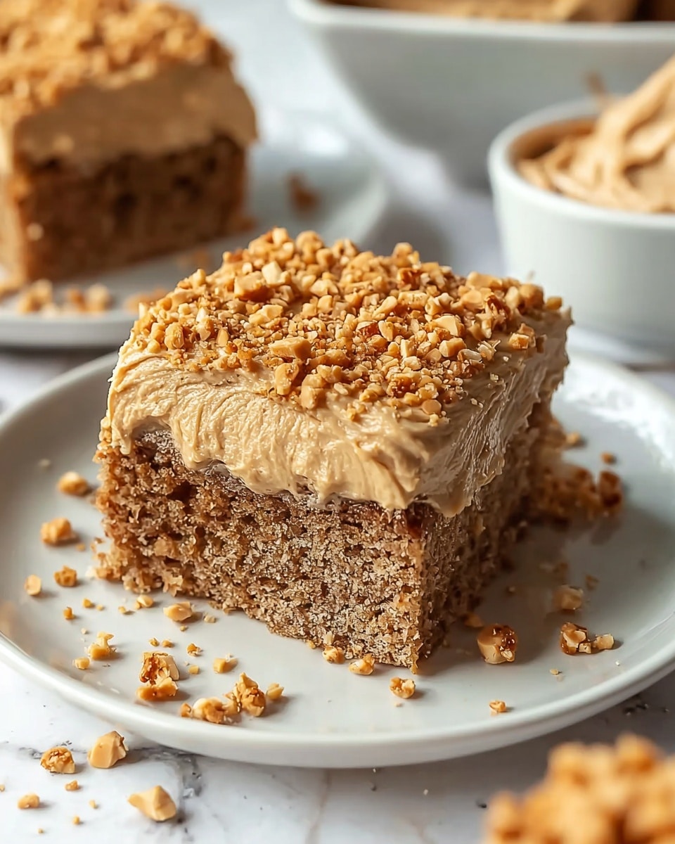 A square piece of cake on a white plate, showing two layers. The bottom layer is dense and brown with a slightly rough texture, while the top layer is a thick, creamy light brown frosting. The frosting is covered with a generous amount of small crushed nuts, adding a crunchy texture and golden color. Crumbs are scattered around the plate on a white marbled surface, with a blurred bowl of more crushed nuts and another bowl of light brown frosting in the background. photo taken with an iphone --ar 4:5 --v 7