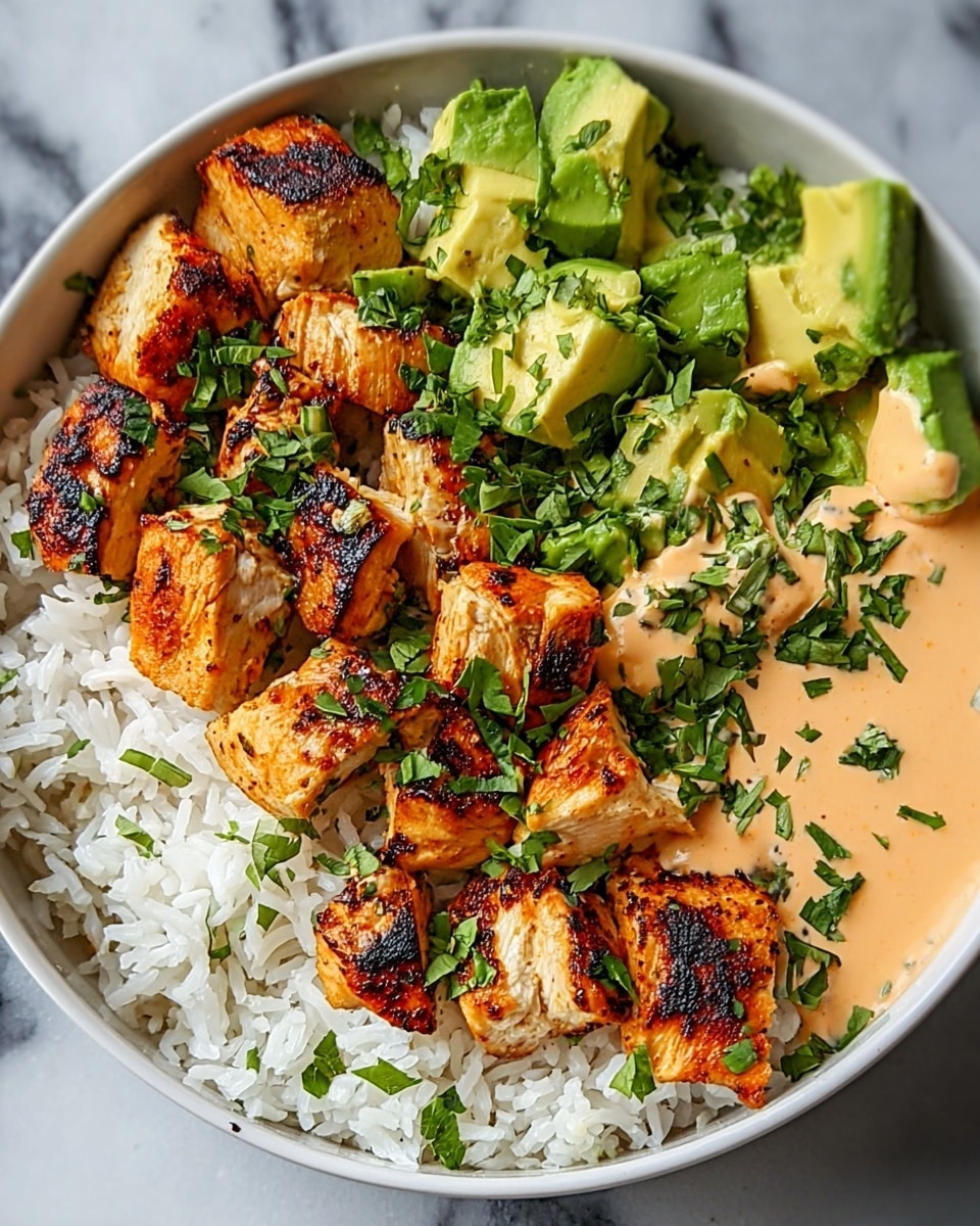 A white bowl filled with a bed of fluffy white rice at the bottom, topped with golden-brown grilled chicken pieces that have char marks and look juicy, arranged mainly on one side. Next to the chicken, there are fresh green avocado chunks with a creamy texture, some chopped green herbs scattered on top for a fresh touch. On the other side of the rice, there is a creamy light orange sauce drizzled, also garnished with chopped green herbs. The bowl sits on a white marbled surface. photo taken with an iphone --ar 4:5 --v 7