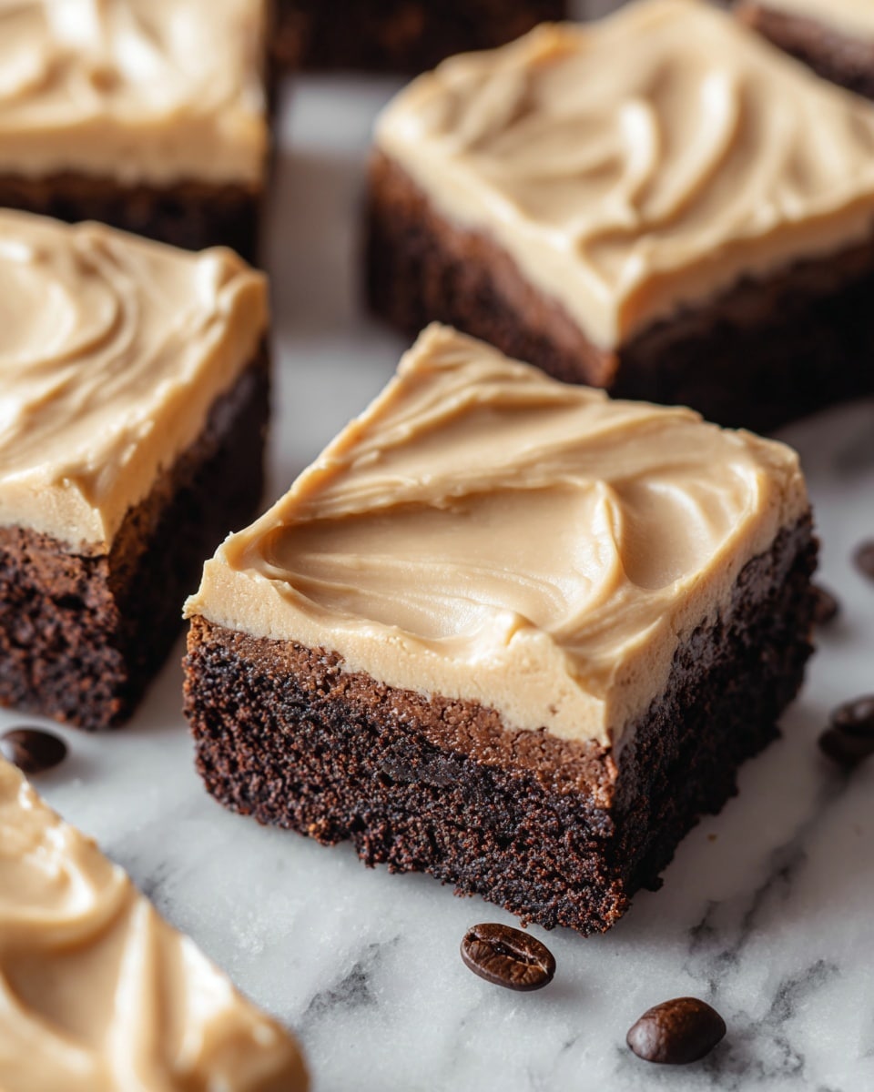 The image shows several square chocolate brownies with two layers each, placed closely together on a white marbled surface. The bottom layer is dark brown and looks soft and moist, with a slightly crumbly texture. The top layer is a thick, smooth, light beige frosting spread evenly with soft swirling patterns. The edges of the brownies reveal the contrast between the dark base and creamy frosting. Scattered around the brownies are a few dark brown coffee beans, adding a rich touch to the scene. photo taken with an iphone --ar 4:5 --v 7