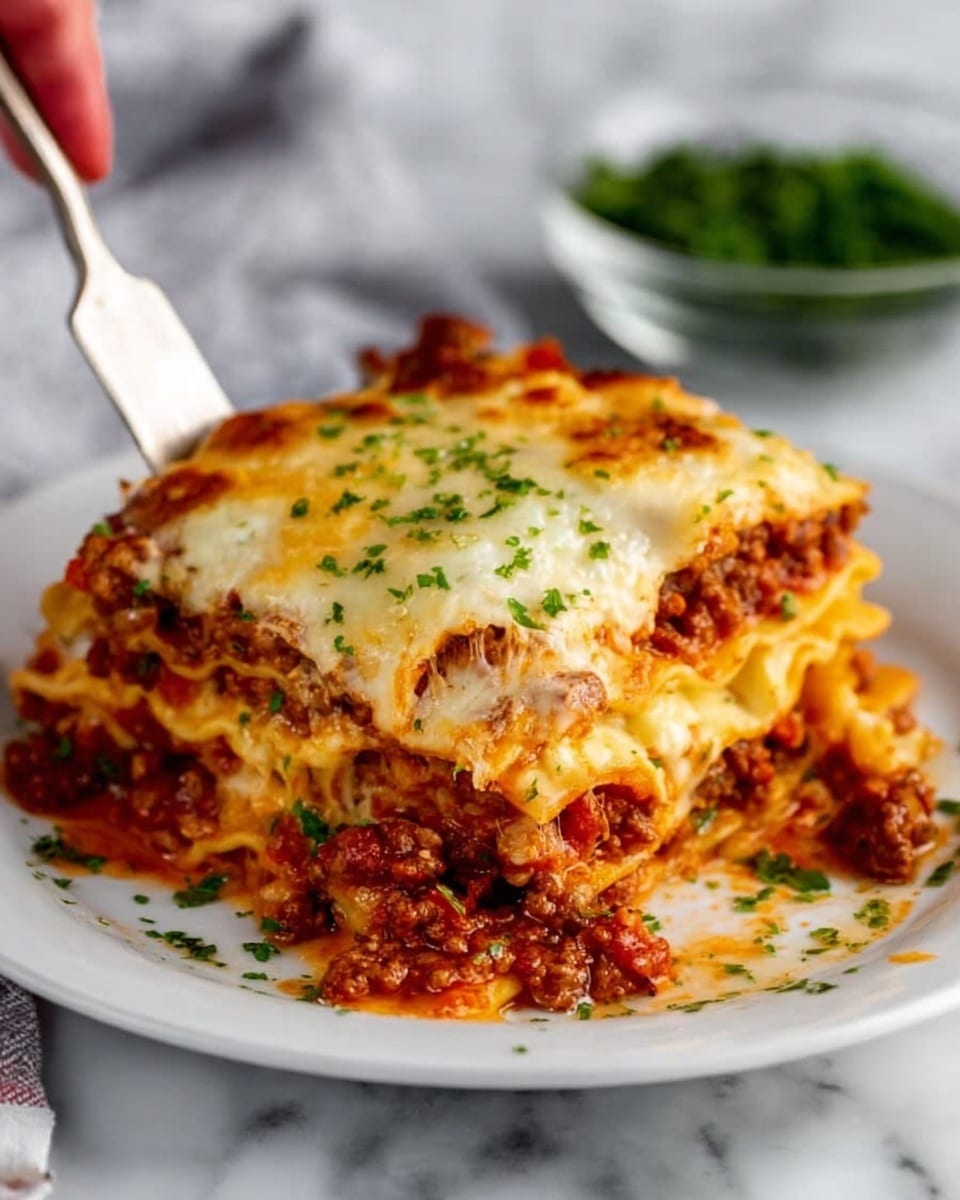 A white rectangular baking dish filled with six large square pieces of lasagna. The top layer is covered evenly with melted, golden-brown cheese that has small browned spots scattered across, with some green herbs sprinkled on top. Beneath the cheese, layers of tomato sauce peek through with a rich red color around the edges, blending into the sides of the dish. The surface underneath the baking dish is a white marbled texture, and a white cloth is partially visible at the bottom left corner. photo taken with an iphone --ar 4:5 --v 7