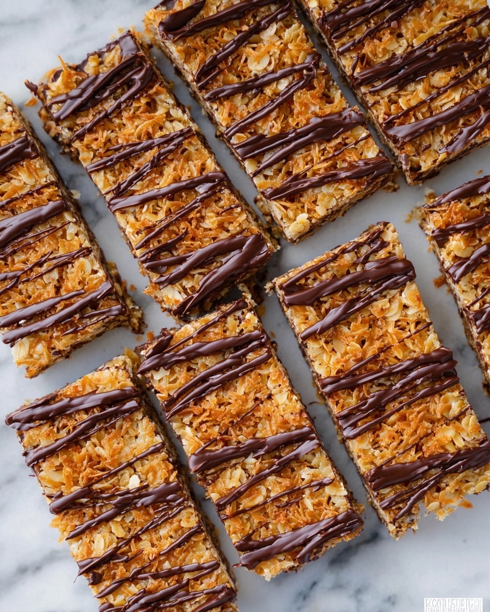 The image shows a wooden board with a stack of five round cookies topped with shredded toasted coconut and half-dipped in dark chocolate, arranged in the center background. In the foreground, three square bars with a dark chocolate base, a thick caramel and shredded coconut middle layer, and a drizzle of dark chocolate on top are placed on the board. The dark chocolate drizzles form thin lines and small shapes, adding texture and contrast to the caramel and coconut layer. The background has a white marbled texture with a blurred checkered cloth. Photo taken with an iphone --ar 4:5 --v 7