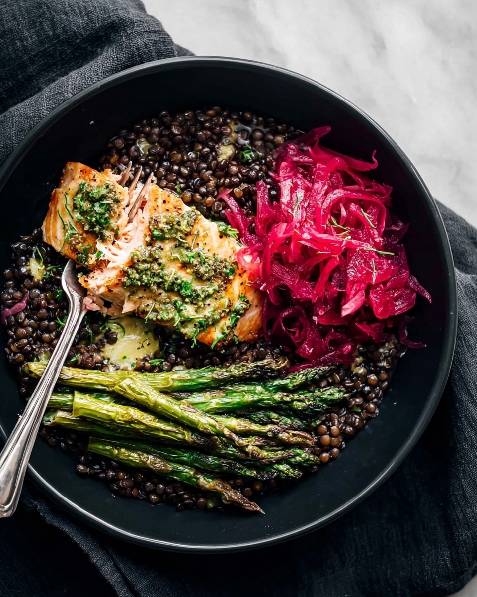 A black bowl holds a layered dish with a bottom layer of dark cooked lentils that cover the entire base, topped with three sections: a piece of cooked salmon with a light golden crust and green herb sauce sprinkled on top near the center, a portion of bright red shredded pickled cabbage to the right of the salmon, and a small pile of green roasted asparagus spears with light char marks placed below the cabbage and beside the salmon. A silver fork breaking the salmon is visible in the upper left part of the bowl. The bowl is placed on a dark cloth, all set on a white marbled surface. Photo taken with an iphone --ar 4:5 --v 7