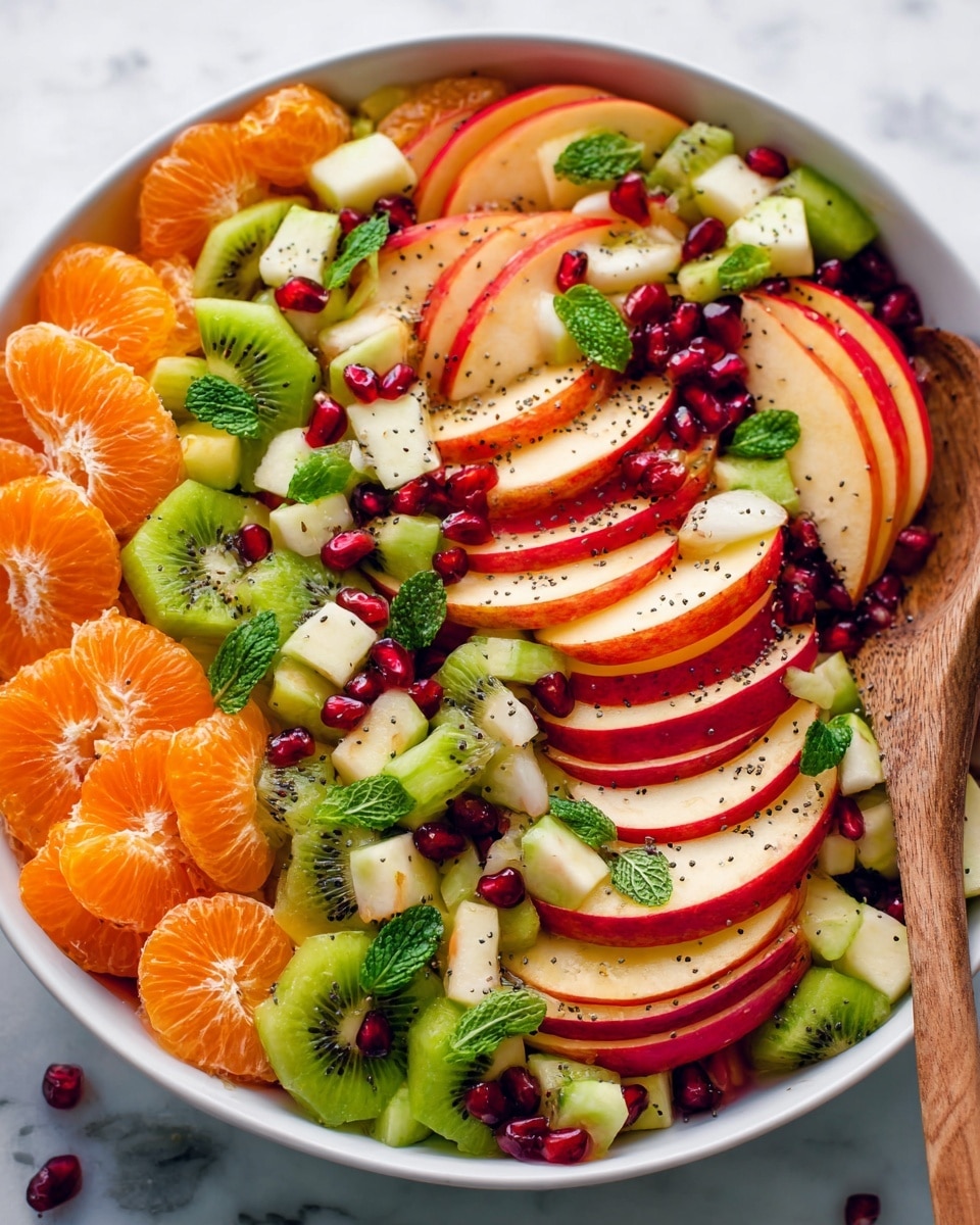 A colorful fruit salad in a white bowl sitting on a white marbled surface, featuring three main layers: the bottom layer full of round, bright orange mandarin slices; the middle layer showing thin red apple slices with smooth edges arranged in overlapping rows; and the top layer with chopped green kiwi pieces and small white apple chunks. Scattered throughout the salad are shiny, deep red pomegranate seeds which add pops of color, and small green mint leaves for freshness. Tiny black poppy seeds are sprinkled over the entire salad, adding texture and contrast. A wooden spoon rests on the right side inside the bowl. Photo taken with an iphone --ar 4:5 --v 7