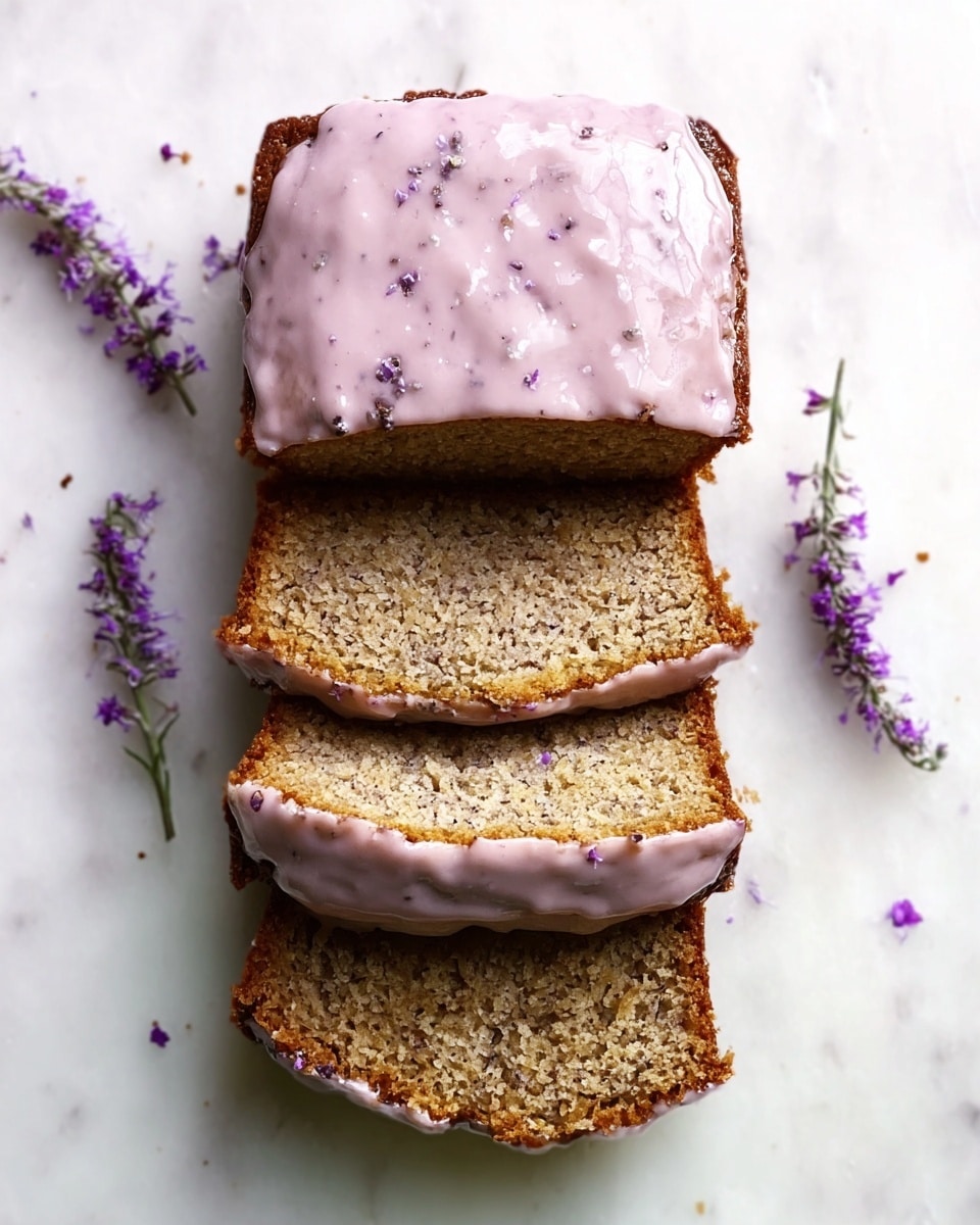 A loaf of bread with three thick slices cut, each slice showing a dense, moist inside with a light brown color filled with small dark specks. The top of the bread and the slices have a layer of pale pink icing with visible small purple flecks unevenly spread, slightly dripping over the edges. The bread is placed on a white marbled surface with small sprigs of purple flowers scattered around on the right side. photo taken with an iphone --ar 4:5 --v 7